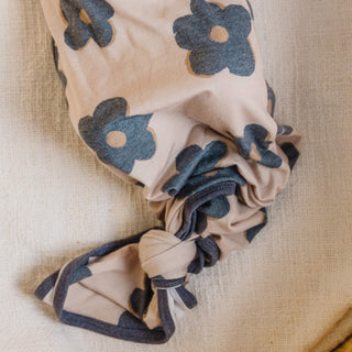 Beige headband with blue floral patterns on a beige fabric background