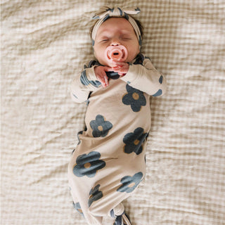 Newborn baby wrapped in a floral swaddle on a textured blanket