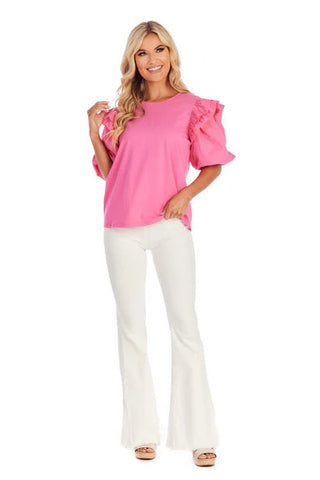 Woman wearing a pink blouse and white pants on a white background