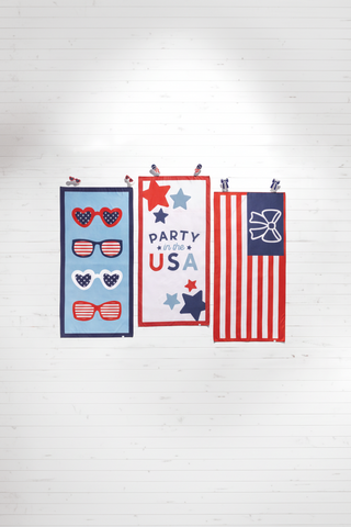Decorative towels with patriotic designs on a white wooden background