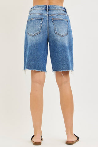 Blue denim shorts worn by a person on a white background