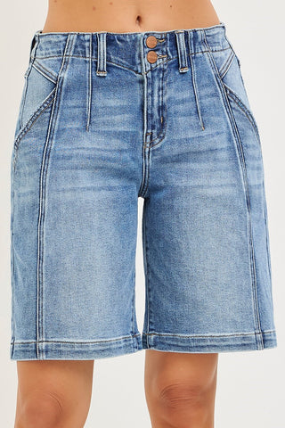 Blue denim shorts worn by a person on a white background