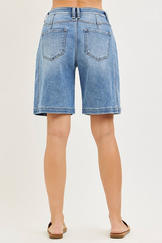 Blue denim shorts worn by a person on a white background