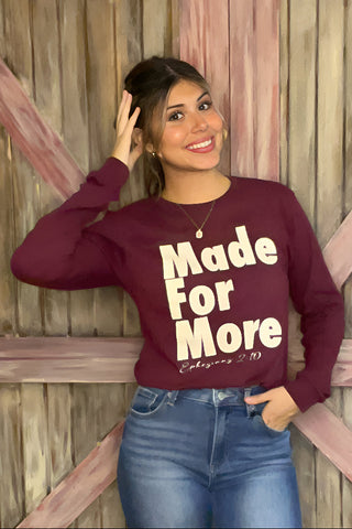Woman wearing a maroon sweatshirt with text standing against a wooden background