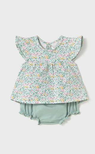 A baby girl's two-piece outfit featuring a short-sleeve top with a green, pink, and yellow floral print, paired with matching sage green ruffled bloomers, shown on a light gray background.