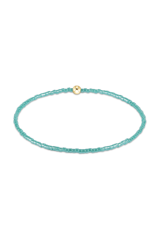 Turquoise beaded bracelet with a gold clasp on a white background