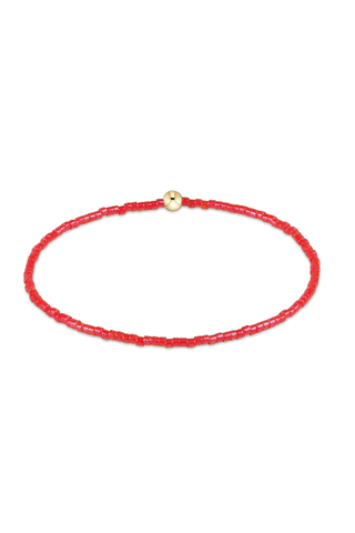 Red beaded bracelet with a gold clasp on a white background