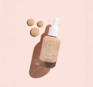 Skincare serum bottle with dropper on a pink background