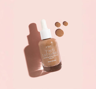 Serum bottle labeled 'Tint-National' on a pink background