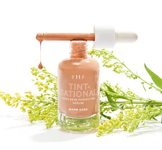 FH F Tint-Sational serum bottle with dropper on a white background with green leaves.