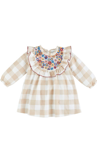 A vintage embossed dress with a ruffled neckline and sleeveless design, featuring a beige and white checkered pattern with red accents.