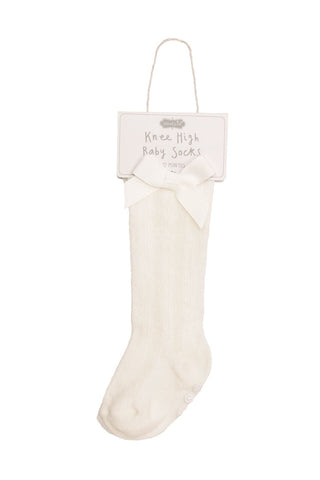 White knee-high baby socks on a white background with a label.