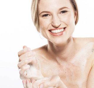 Woman applying soap to her hands with a white background