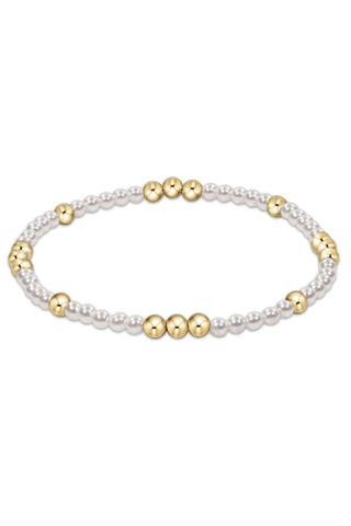 Bracelet with alternating gold and pearl beads on a white background