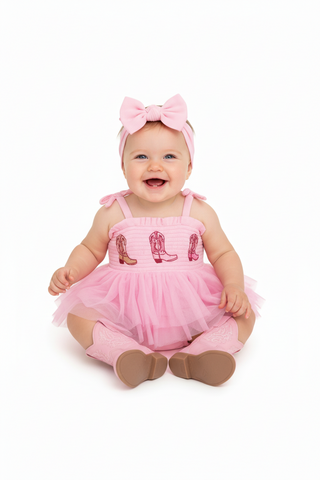 Pink romper with cowboy boot designs on a white background
