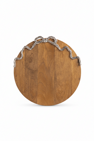 Wooden round cutting board with silver metal handles on a white background