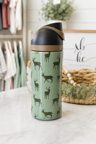 green water bottle with deer print set on a counter in a boutique