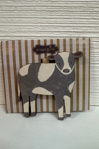 Cow wood chip clip on striped cardstock in front of a wooden wall