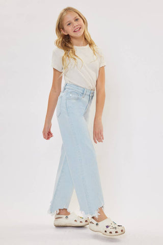 Young girl wearing a white t-shirt and light blue jeans on a white background