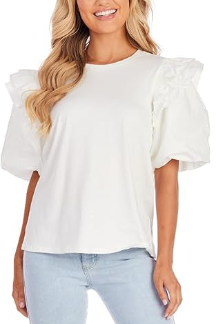 Woman wearing a white blouse with ruffled sleeves and light blue jeans.