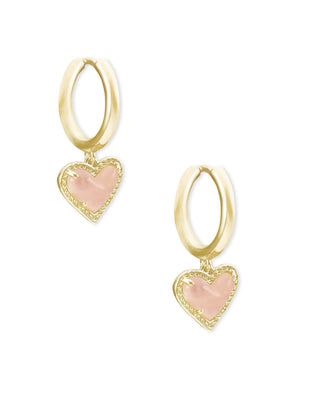 Gold hoop earrings with pink heart charms on a white background