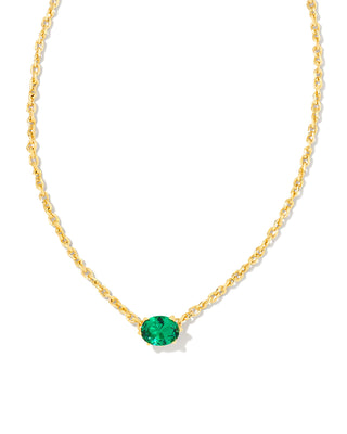 Gold necklace with a green gemstone on a white background