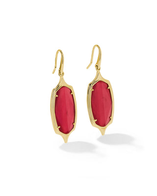 A pair of gold drop earrings featuring elongated marquise-shaped pinkish-red cabochon gemstones, displayed on a clean white background with soft shadows.