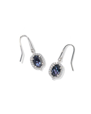 A pair of silver drop earrings featuring oval-cut dark blue iridescent gemstones surrounded by small clear stones, set against a plain white background.