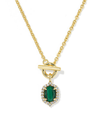 A gold chain necklace with a toggle clasp and a teardrop-shaped green emerald pendant, surrounded by a halo of small clear stones, shown on a white background.