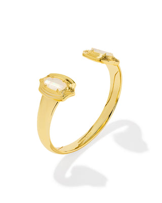 A gold open cuff ring featuring two oval-cut milky white gemstones, displayed on a clean white background with a soft shadow.