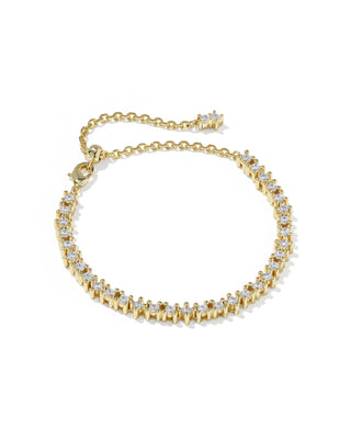 A gold tennis bracelet featuring a row of small, round-cut clear gemstones in prong settings, with an adjustable chain extension and clasp, shown on a plain white background.