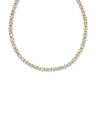 A delicate gold tennis necklace adorned with small clear gemstones, displayed against a solid white background.