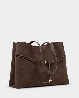 Brown leather handbag with a strap on a light gray background