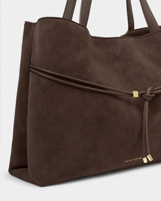 Brown leather tote bag with drawstring on a light gray background