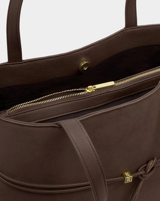 Brown leather handbag with gold zipper and clasp on a light gray background