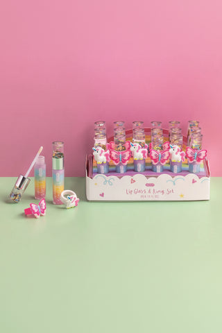 lip gloss and ring set in box on a pink and green background