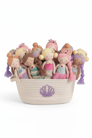 Set of mermaid-themed dolls in a woven basket on a white background