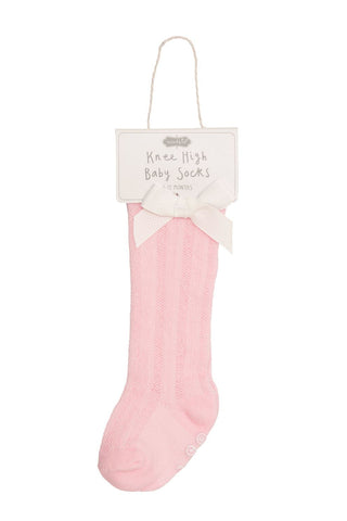 Pink knee-high baby socks with a white label on a white background